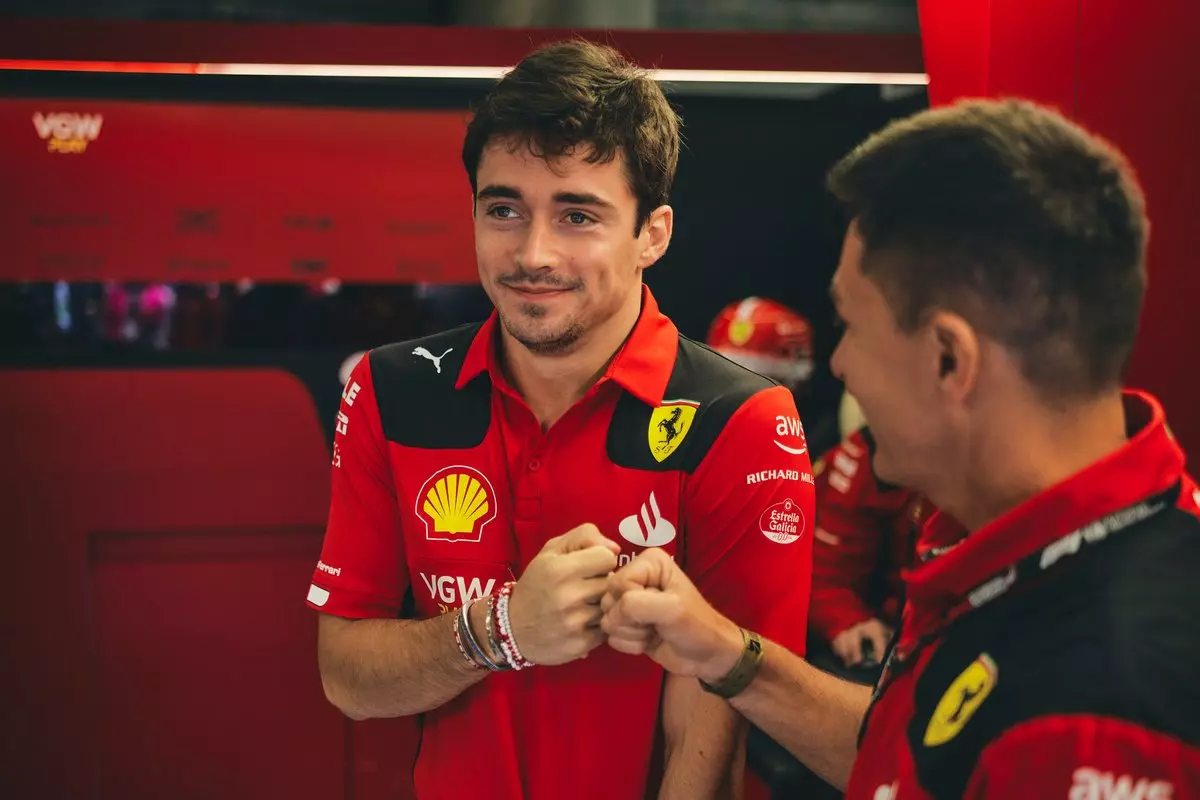 Charles Leclerc nei box insieme agli ingegneri Ferrari